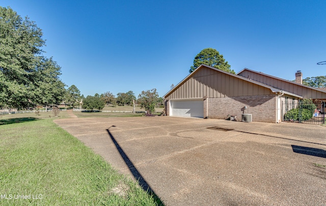 view of side of property with central AC unit and a garage