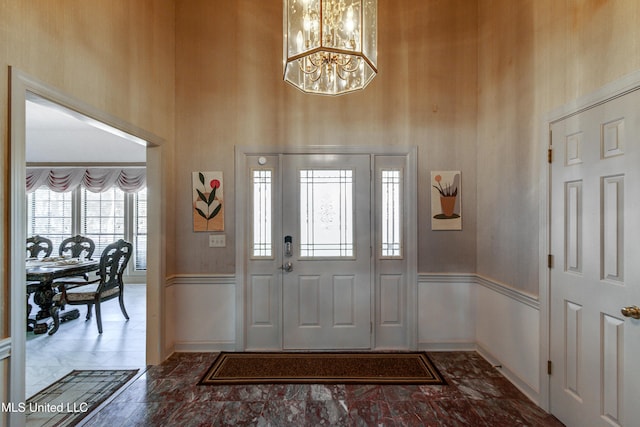 foyer with a high ceiling and a notable chandelier