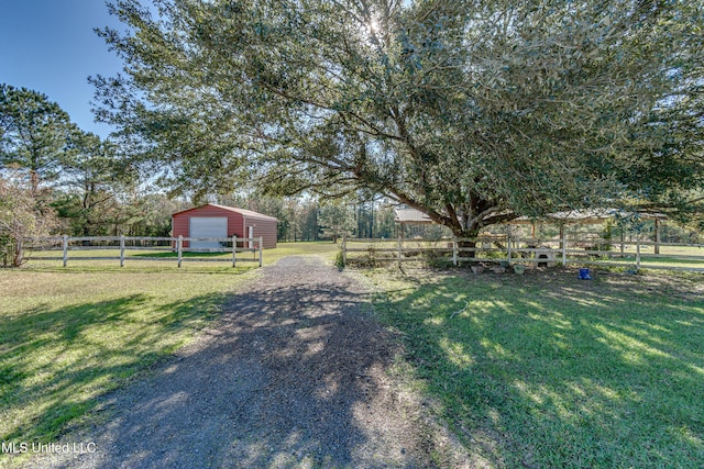 view of yard with an outbuilding, a rural view, and a garage