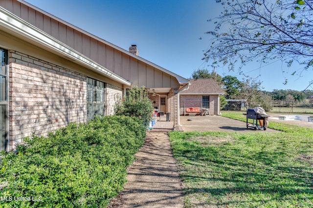 back of property featuring a lawn and a patio