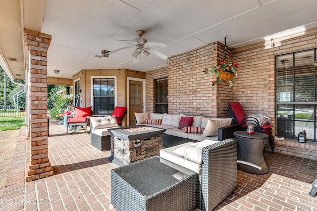 view of patio featuring ceiling fan and an outdoor living space with a fire pit