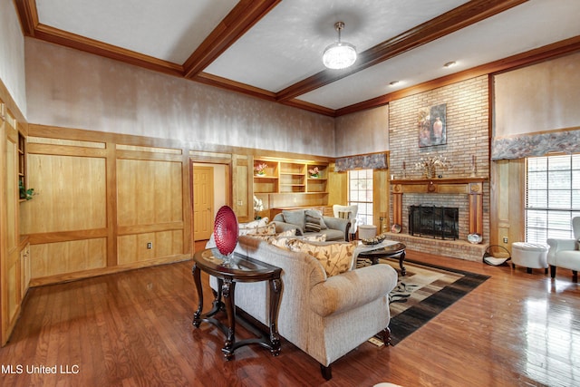 living room with beamed ceiling, wood-type flooring, and a brick fireplace