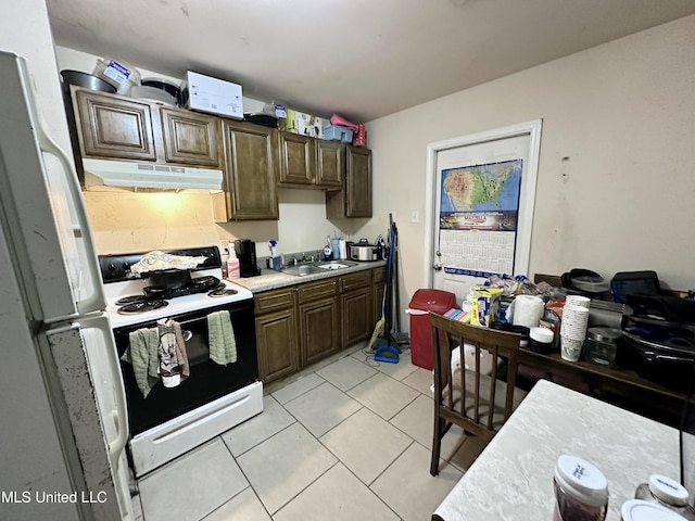 kitchen with range with electric stovetop, light tile patterned flooring, sink, white fridge, and dark brown cabinetry