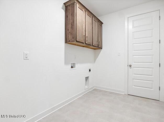 laundry room with electric dryer hookup, hookup for a washing machine, and cabinets