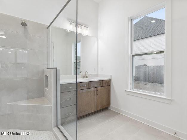 bathroom featuring vanity, a shower with door, and a wealth of natural light