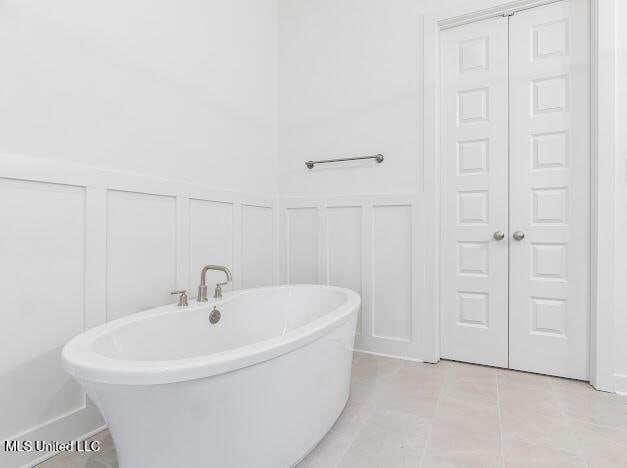 bathroom with tile patterned flooring and a tub to relax in