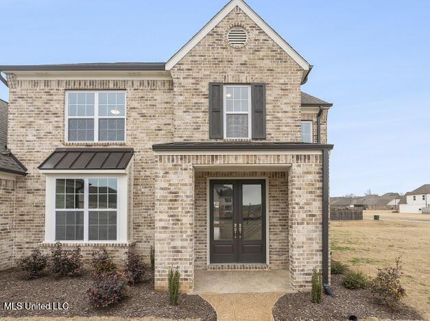 view of front of property featuring brick siding and french doors