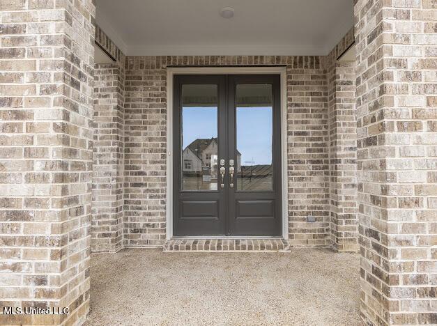 doorway to property with french doors and brick siding