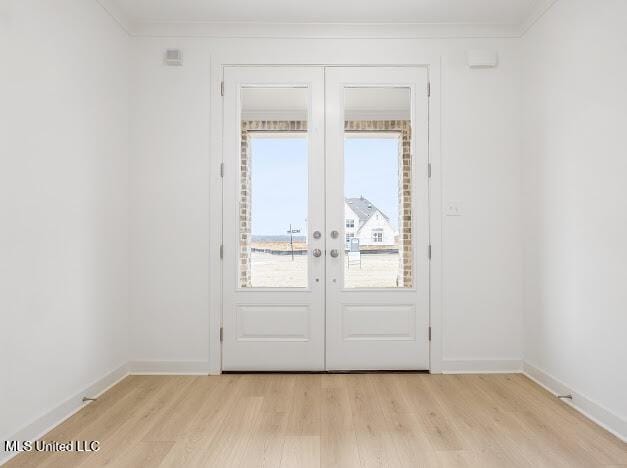 doorway to outside with ornamental molding, french doors, and light wood-style flooring