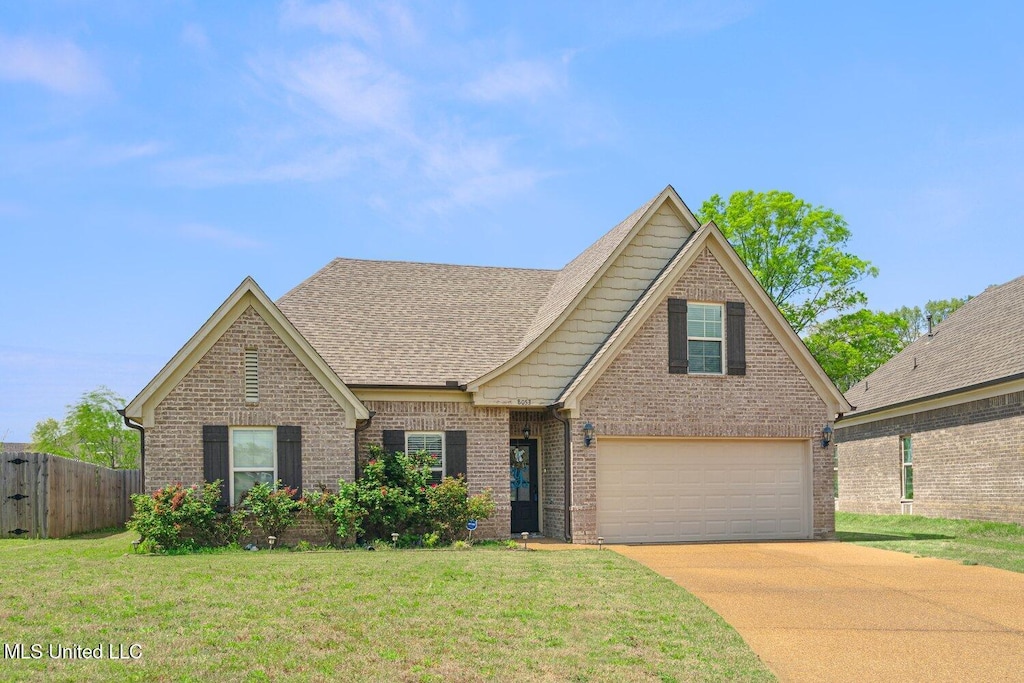 8053 Switzer Dr, Southaven, MS 38671 - traditional home featuring fence, roof with shingles, a front yard, brick siding, and driveway