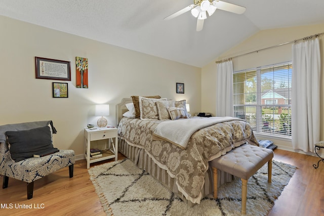 bedroom featuring ceiling fan, light wood-type flooring, and vaulted ceiling