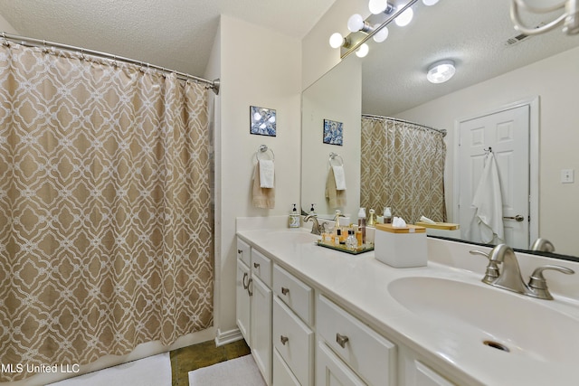 bathroom featuring a shower with curtain, vanity, and a textured ceiling