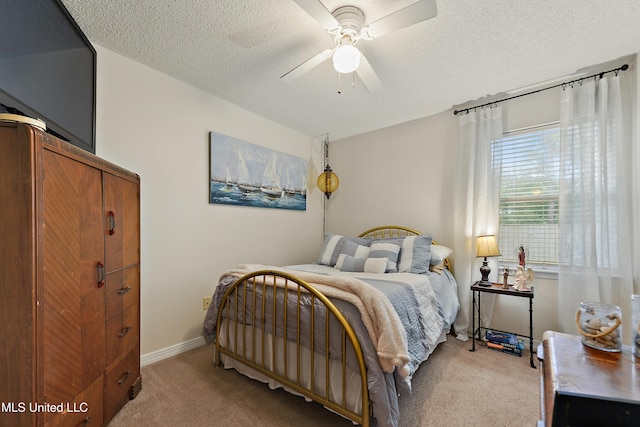 bedroom with ceiling fan, light carpet, and a textured ceiling