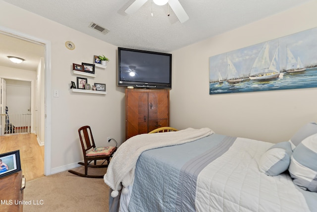 carpeted bedroom featuring a textured ceiling and ceiling fan