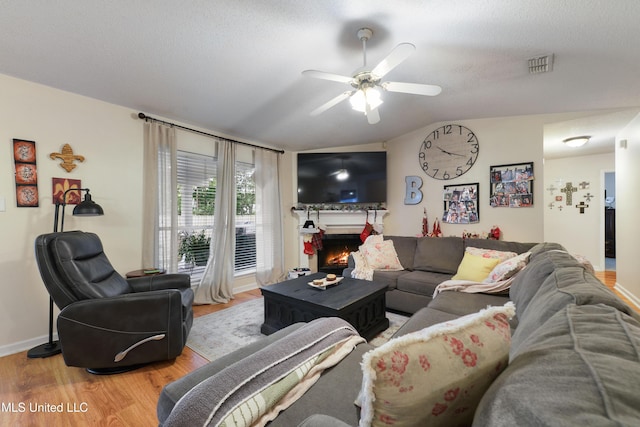 living room featuring ceiling fan, wood-type flooring, and a textured ceiling