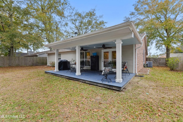 rear view of property featuring central AC unit, ceiling fan, a yard, and a wooden deck