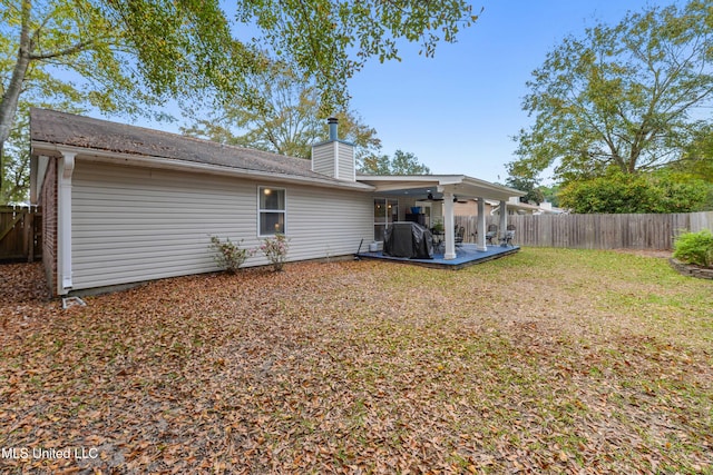 back of property with a yard and a patio