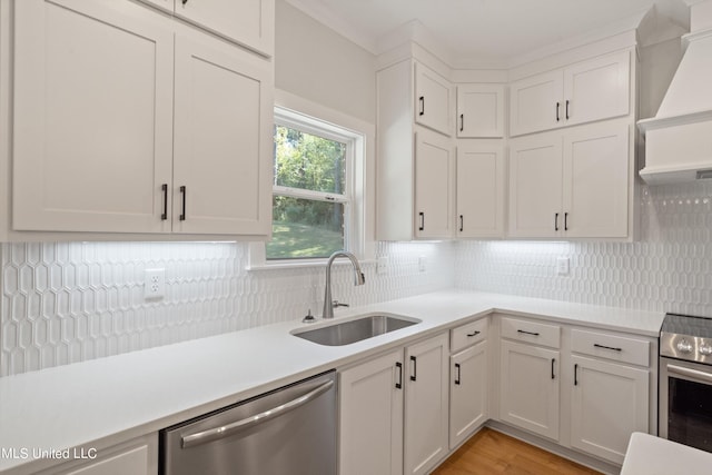 kitchen with white cabinetry, stainless steel appliances, sink, and backsplash