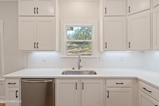 kitchen with stainless steel dishwasher, sink, white cabinetry, and tasteful backsplash