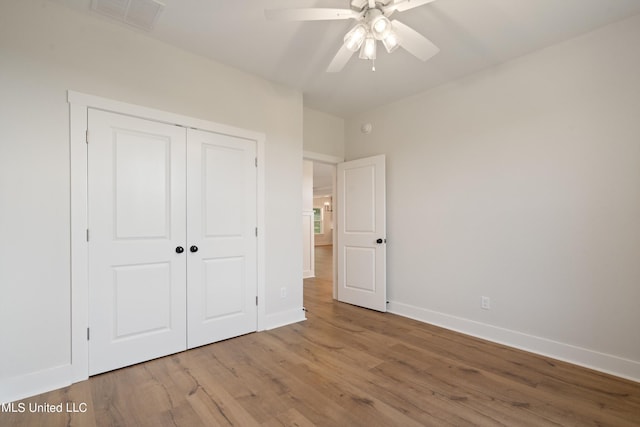 unfurnished bedroom with a closet, light wood-type flooring, and ceiling fan