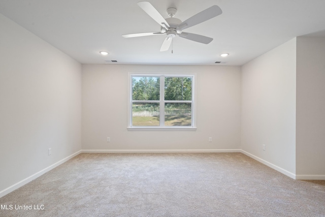 carpeted spare room with ceiling fan