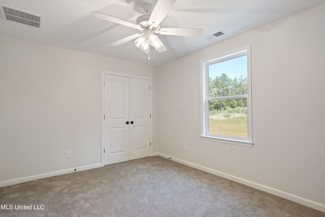 unfurnished bedroom with a closet, ceiling fan, and carpet