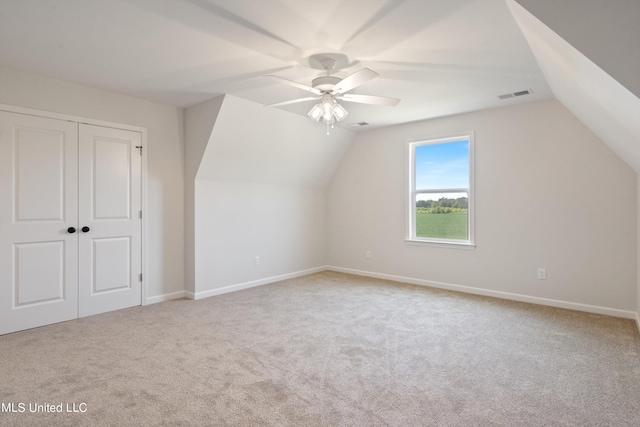 additional living space featuring vaulted ceiling, light colored carpet, and ceiling fan