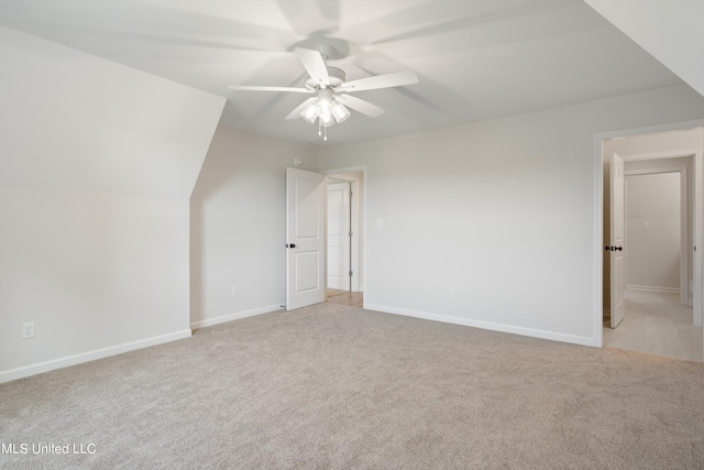 additional living space featuring light colored carpet, vaulted ceiling, and ceiling fan