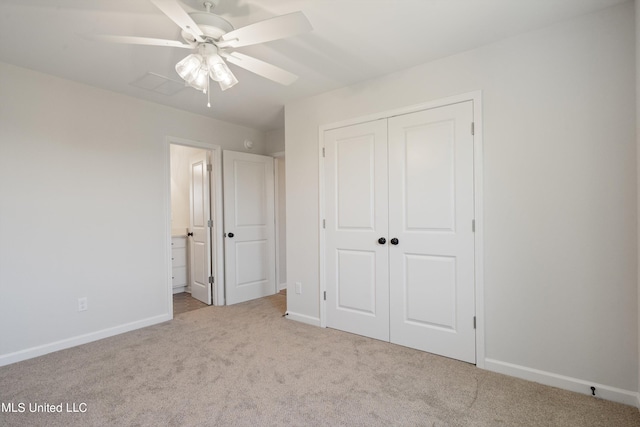 unfurnished bedroom with a closet, light colored carpet, connected bathroom, and ceiling fan