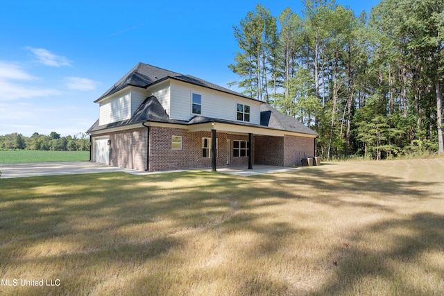 view of front of house with cooling unit, a front lawn, and a garage