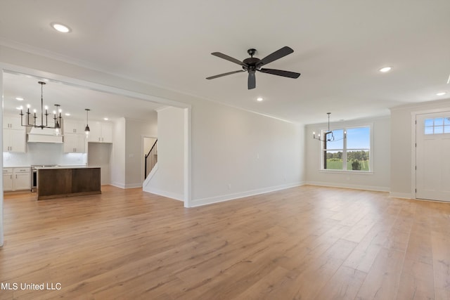 unfurnished living room with light hardwood / wood-style floors, ornamental molding, and ceiling fan with notable chandelier