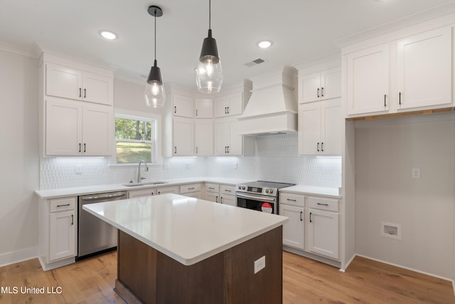 kitchen featuring appliances with stainless steel finishes, sink, light hardwood / wood-style floors, white cabinets, and custom range hood