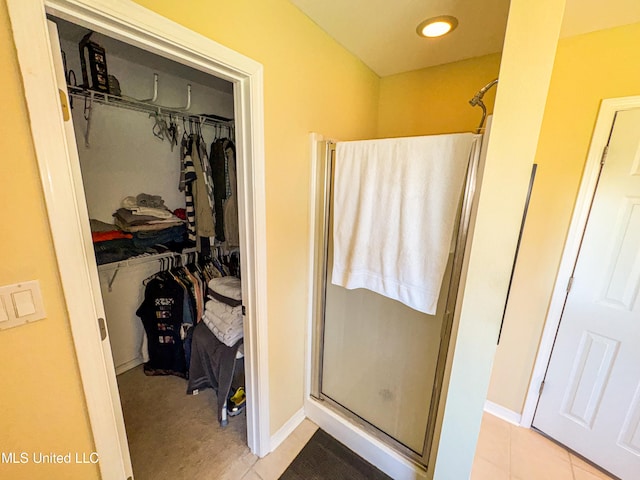 bathroom featuring a shower with shower door and tile patterned flooring