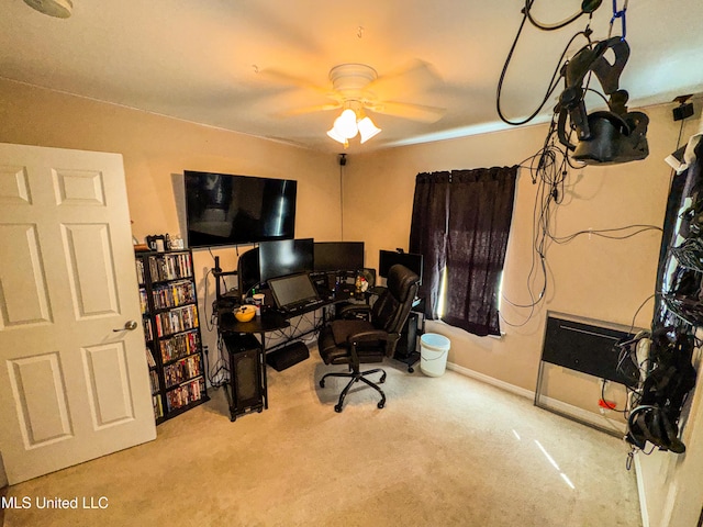 carpeted home office featuring ceiling fan