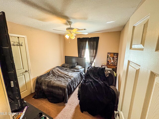 bedroom with carpet, a textured ceiling, and ceiling fan