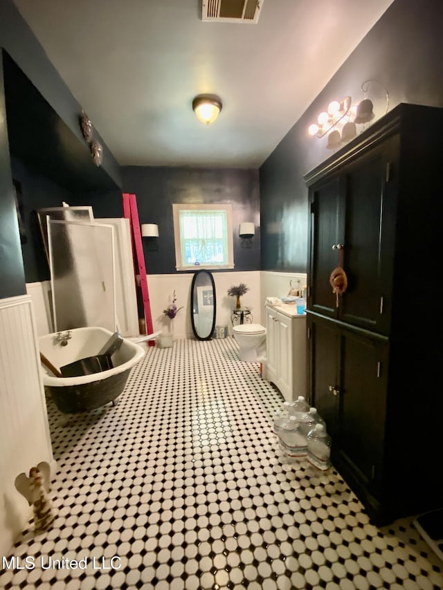 bathroom featuring toilet, tile patterned flooring, and a washtub