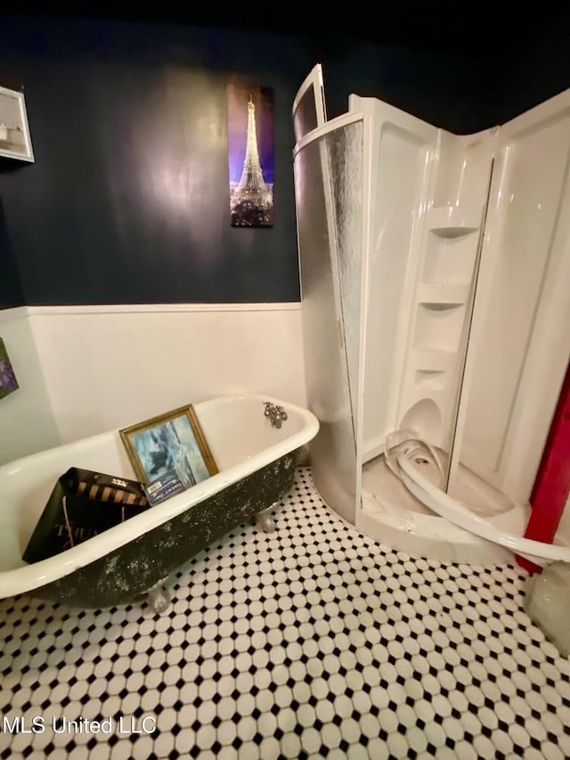 bathroom with tile patterned floors and a tub to relax in