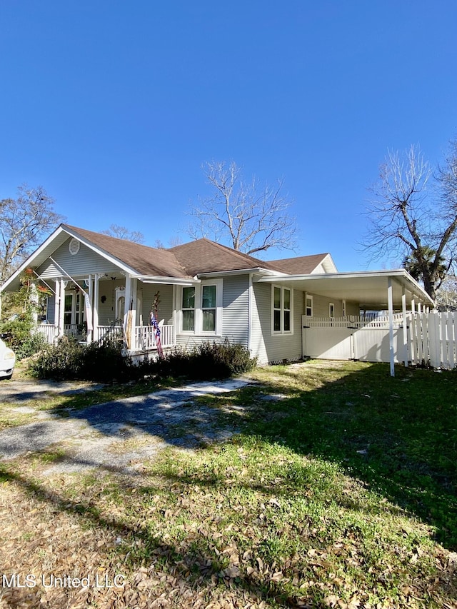 view of side of property featuring a carport and a yard