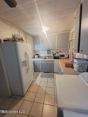 1317 Elise Ave, Yazoo City, MS 39194 - kitchen featuring white fridge with ice dispenser, washer / clothes dryer, light countertops, and light tile patterned flooring