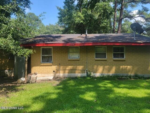 1317 Elise Ave, Yazoo City, MS 39194 - rear view of property with a lawn, a shingled roof, and brick siding