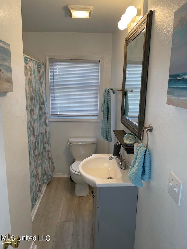 bathroom with vanity, walk in shower, toilet, and wood-type flooring