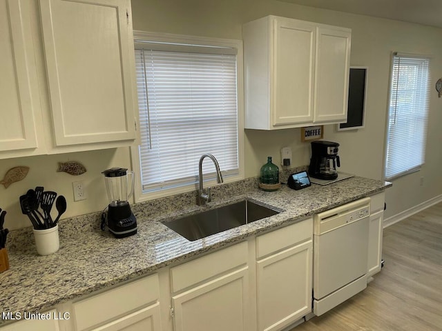 kitchen featuring white cabinets, sink, white dishwasher, and light wood-type flooring