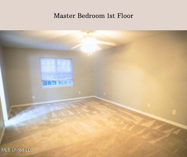 spare room featuring light carpet, a ceiling fan, and baseboards