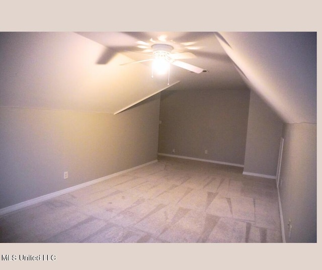 additional living space with a ceiling fan, carpet, baseboards, and vaulted ceiling