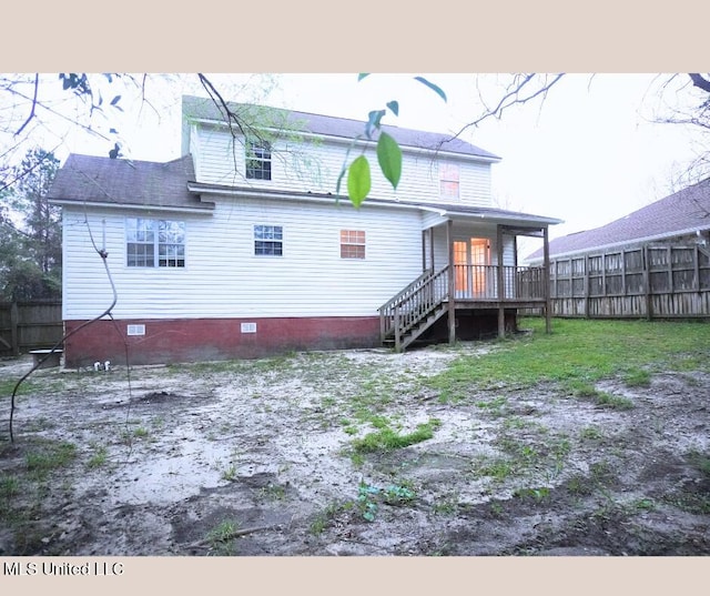 rear view of property featuring crawl space, stairs, and fence