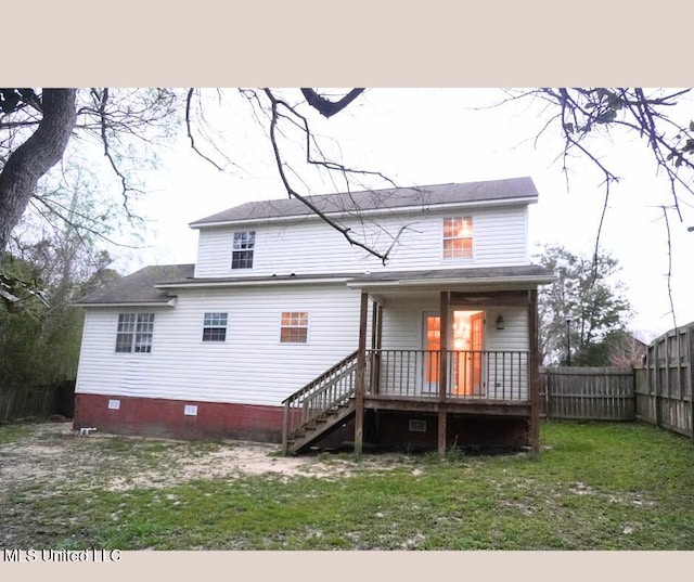 rear view of property featuring stairs, fence, a lawn, and crawl space