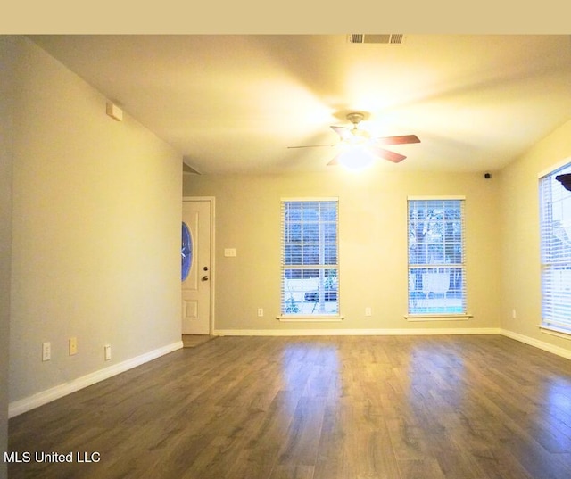 unfurnished room featuring ceiling fan, baseboards, and dark wood-style flooring