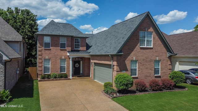 traditional-style house featuring fence, brick siding, concrete driveway, a front yard, and a shingled roof