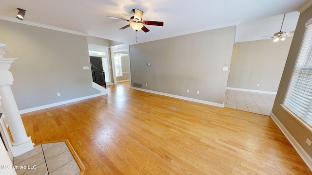 interior space featuring crown molding, visible vents, light wood-style flooring, and a ceiling fan