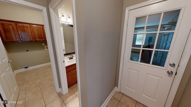 doorway to outside with light tile patterned floors and baseboards